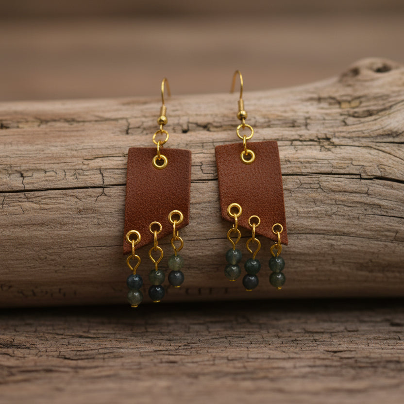 Brown earrings with gold and green beads on a white background