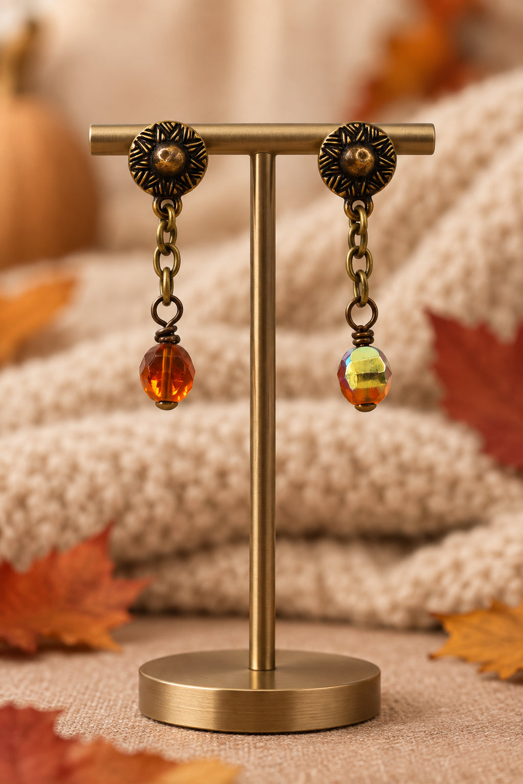 A pair of antique bronze dangle earrings with amber-colored beads, displayed on a white 'River Inspired' brand card.