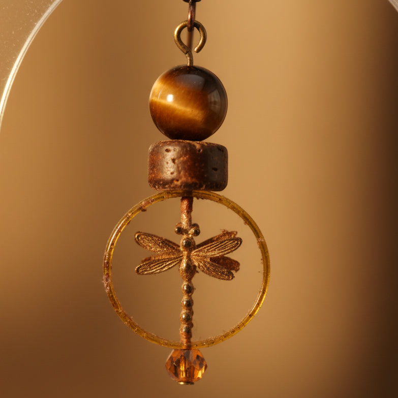 Pair of earrings with circular designs and beads on a white background