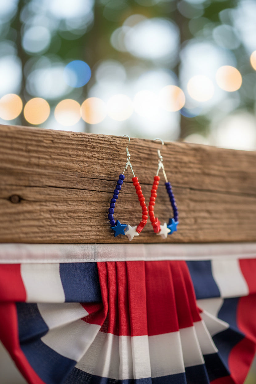 Pair of beaded earrings with red, blue, and white stars on a gray background