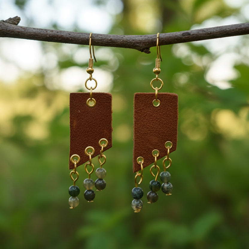 Brown earrings with gold accents and green beads on a white background