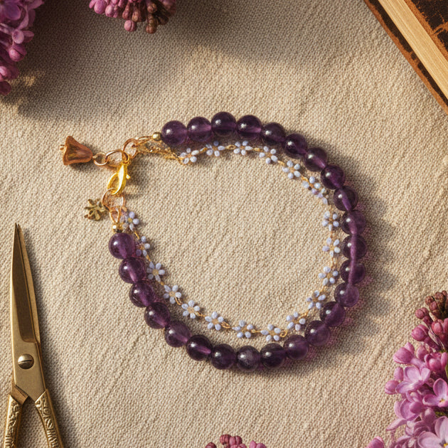 Purple beaded bracelet with gold accents on a gray background