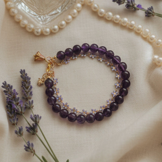 Purple beaded bracelet with gold accents on a gray background
