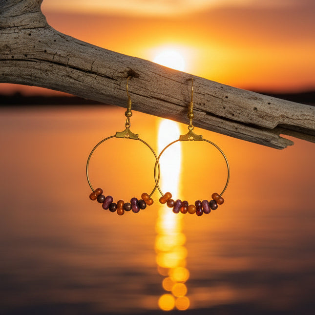 Gold hoop earrings with beads on a 'River Inspired' branded card.