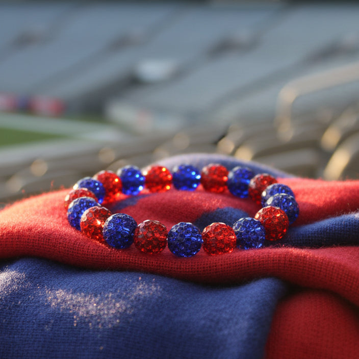 A beaded stretch bracelet featuring alternating red and blue glittery round beads, displayed on a plain light gray background.