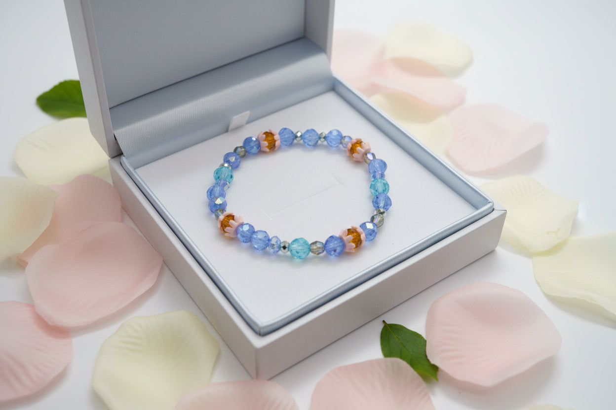 Beaded bracelet with blue, orange, and clear beads on a gray background