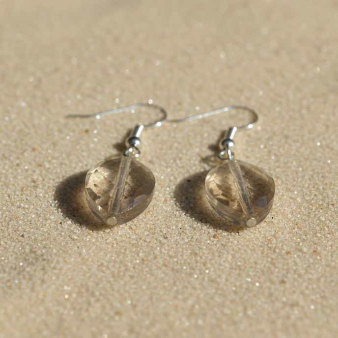 Pair of gold earrings on a gray background