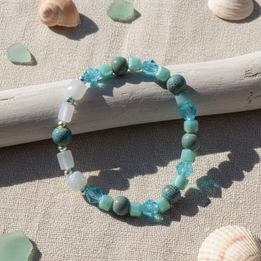 Beaded bracelet with blue and clear beads on a gray background