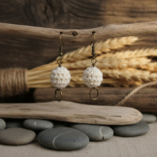 Pair of earrings with textured spherical beads on a white background