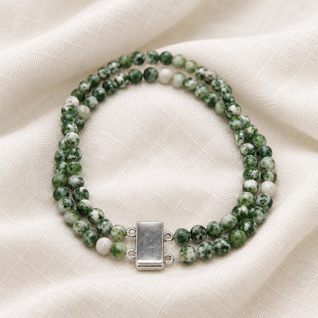 A beaded wrap-style bracelet made of marbled green and white beads with a rectangular silver clasp, photographed on a plain light background.