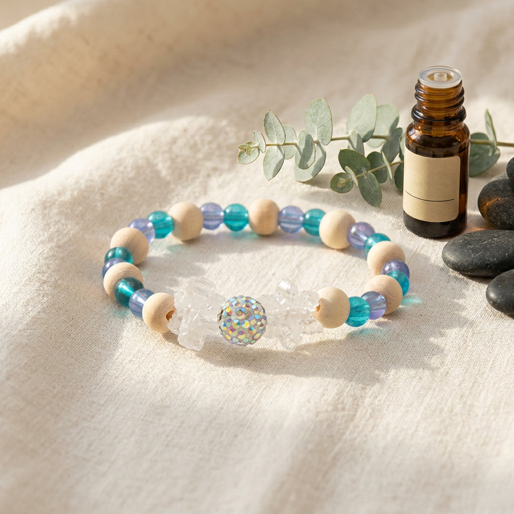 A beaded stretch bracelet featuring light blue and white faceted beads, matte beige wooden beads, and a central clear crystal snowflake charm with a blue iridescent center, set against a plain light gray background.
