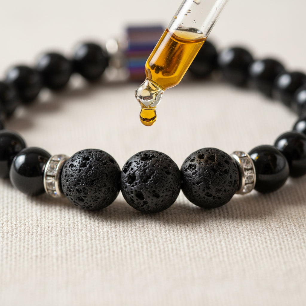 A beaded stretch bracelet featuring matte black round beads and a central metallic cylindrical charm with blue, purple, and red stripes, set against a plain light gray background.