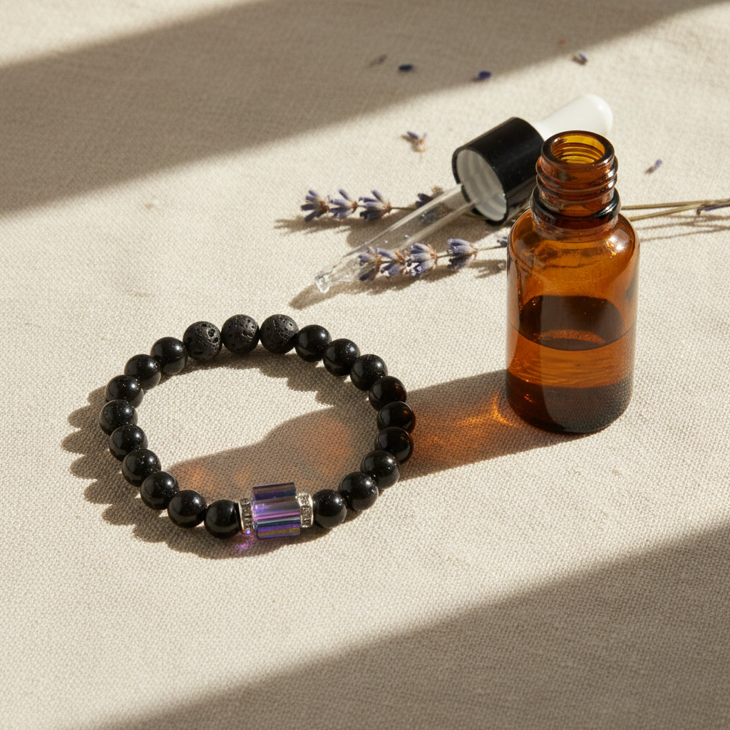 A beaded stretch bracelet featuring matte black round beads and a central metallic cylindrical charm with blue and purple stripes, set against a plain light gray background.