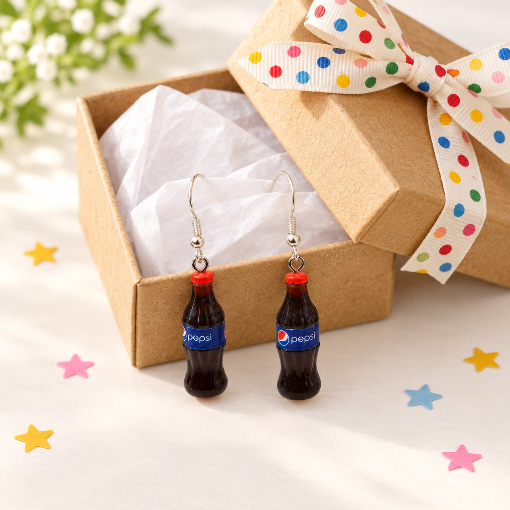 A pair of silver-tone dangle earrings shaped like miniature Pepsi-Cola bottles with red caps, hanging against a light gray background.