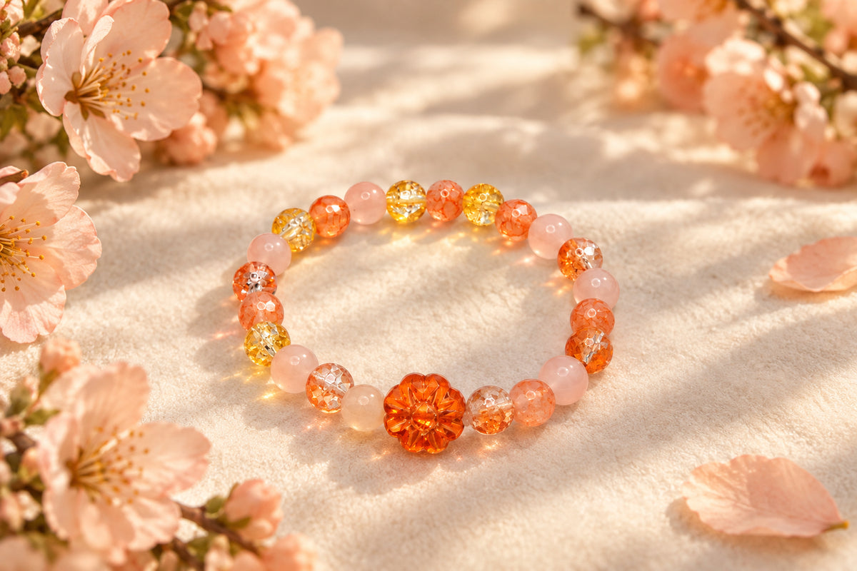 A beaded stretch bracelet featuring translucent peach, orange, and yellow beads, with a prominent textured orange flower-shaped bead at the center, displayed on a plain light gray background.