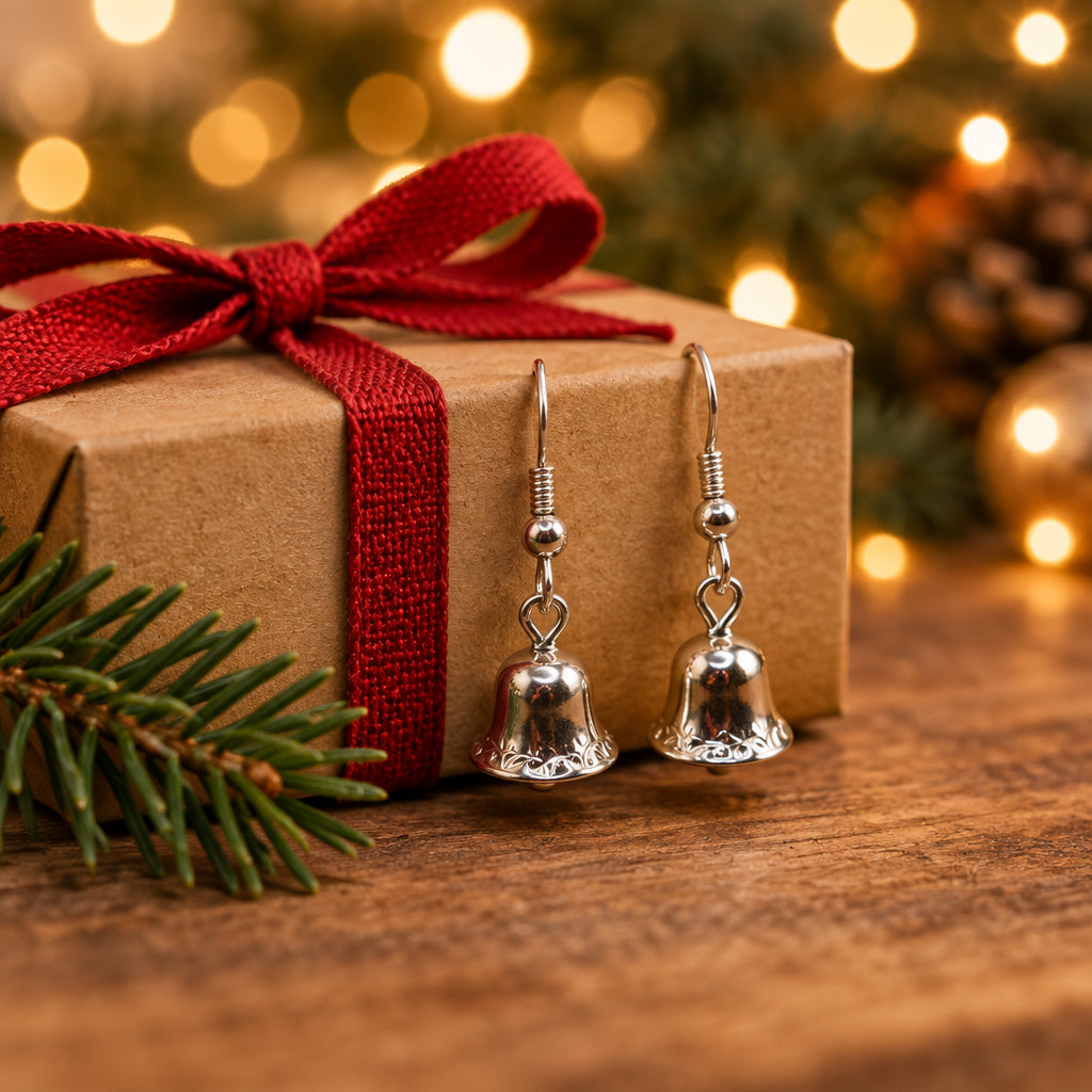 A pair of silver bell-shaped dangle earrings hanging from a clear plastic display stand against a plain light gray background.