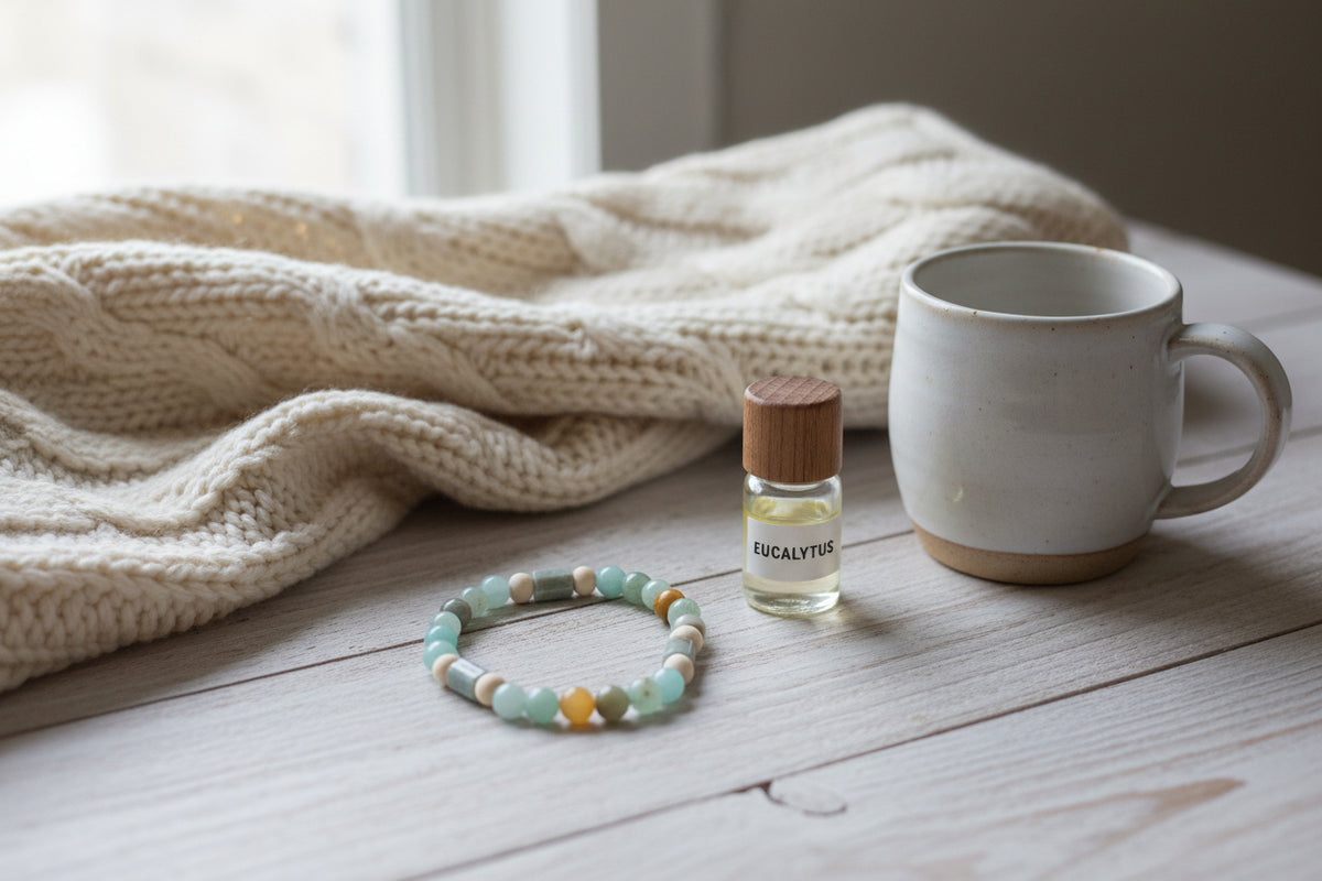 A beaded stretch bracelet made of round and cylindrical beads in light blue, sage green, cream, and brown, arranged in a circle on a light gray background.