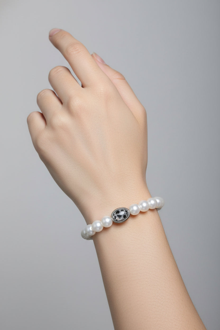 Stretch cord bracelet with white pearls and decorative accent