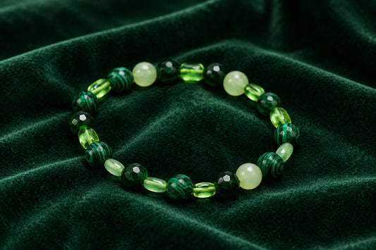 A beaded stretch bracelet made of green and white translucent beads, displayed on a plain light gray background.