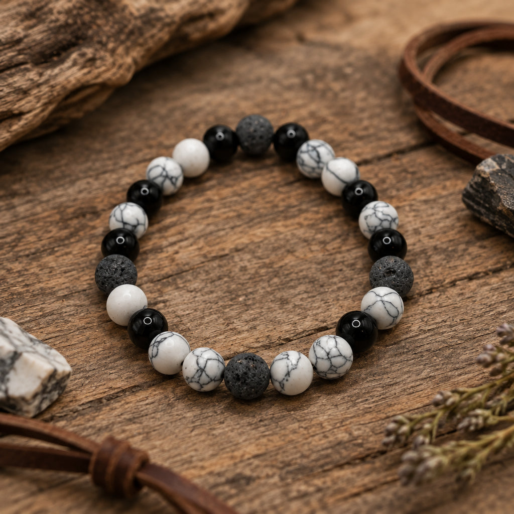 A beaded stretch bracelet made of alternating black and white marbled round beads, displayed on a plain light gray background.