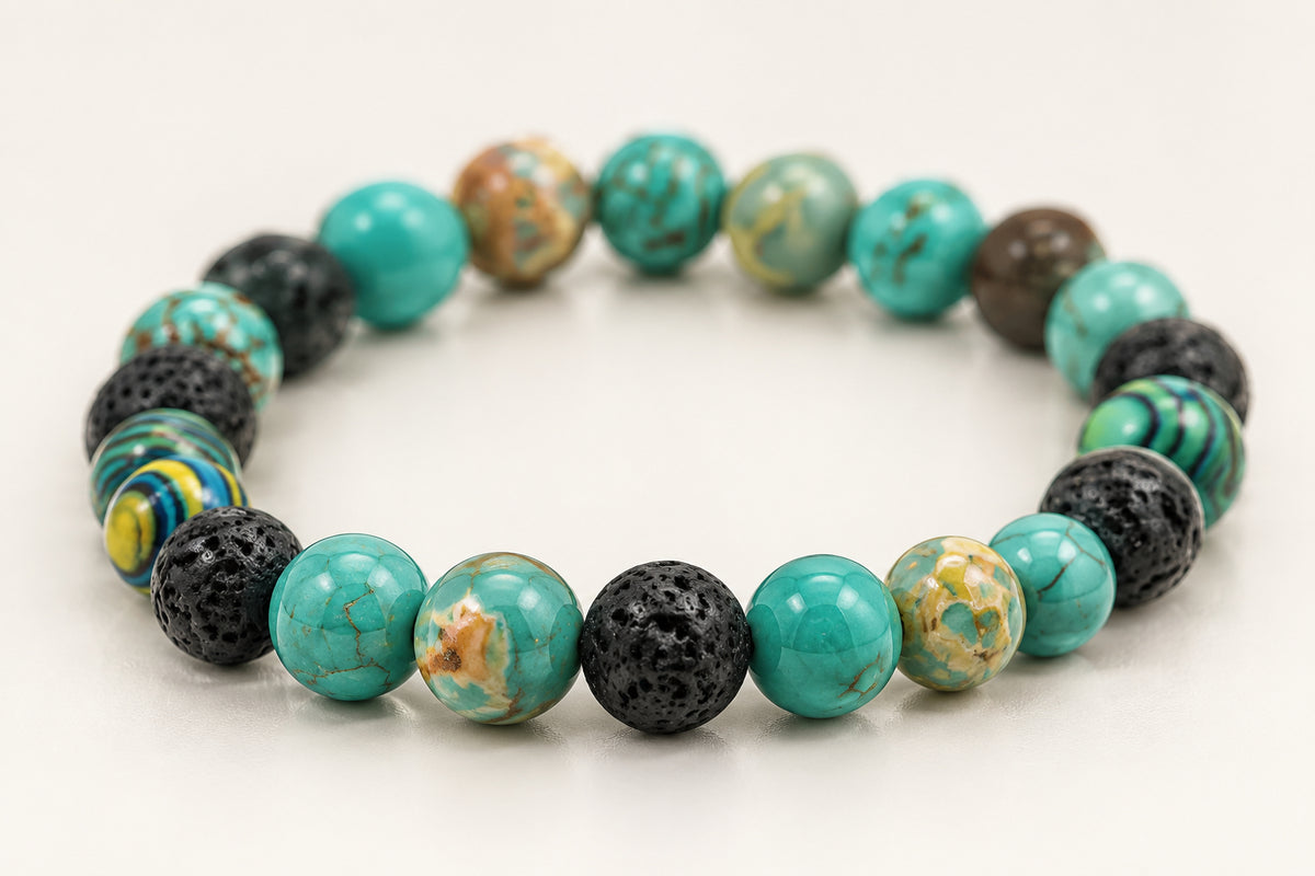 A beaded stretch bracelet made of round turquoise, dark gray, and marbled beads, displayed on a neutral gray background.