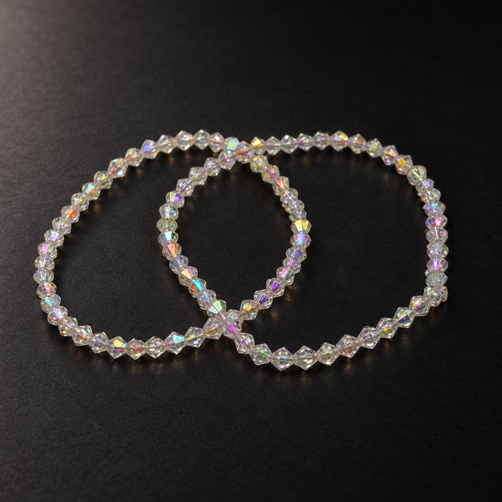 Two beaded stretch bracelets made of small faceted white beads with an iridescent, rainbow-reflecting finish, arranged on a plain light gray background.