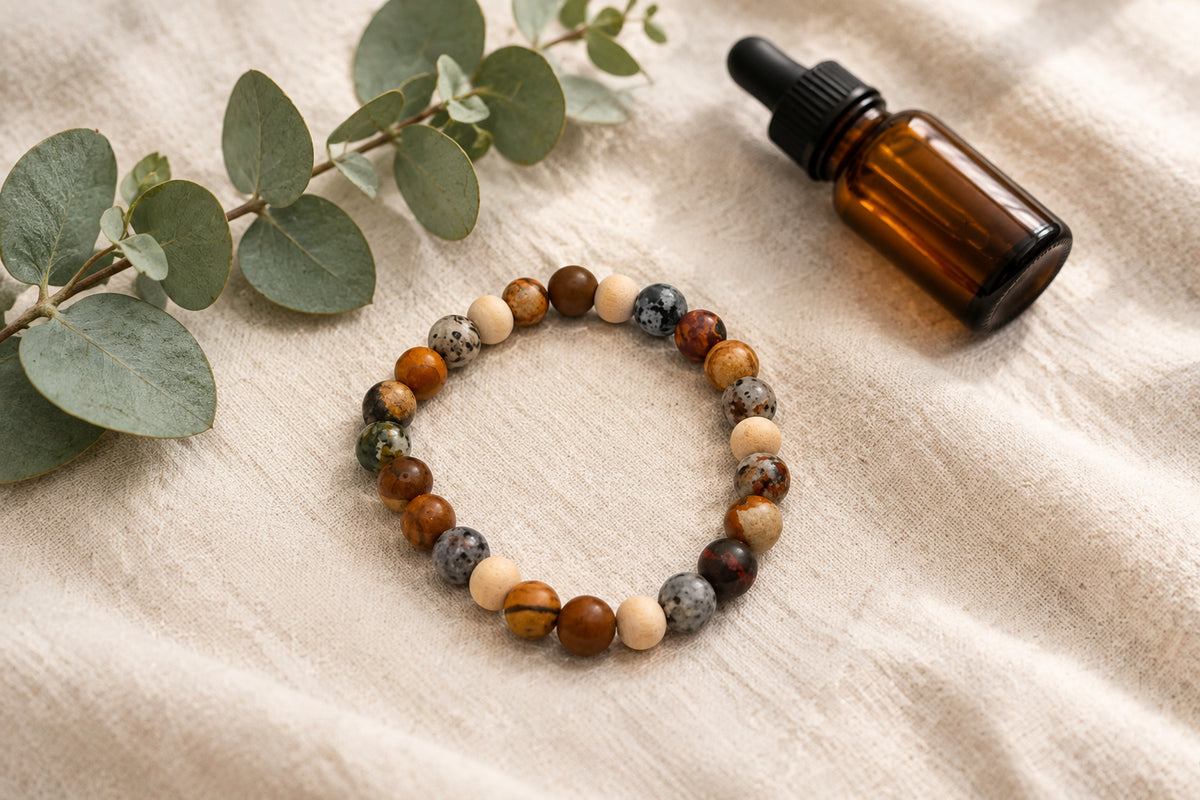 A beaded stretch bracelet made of mixed natural stone beads in brown, gray, and cream, arranged in a circle on a plain light gray background.
