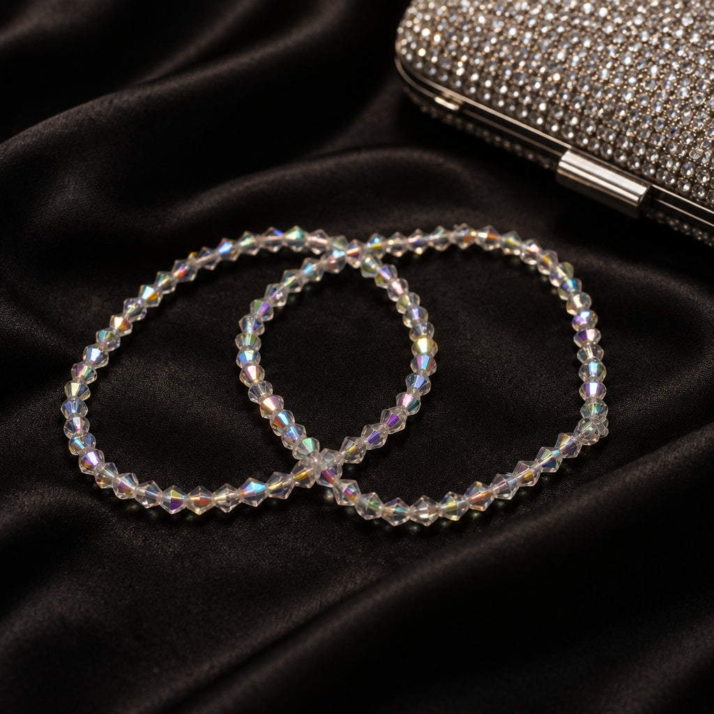 Two beaded stretch bracelets with iridescent white faceted beads, arranged on a plain light gray background.