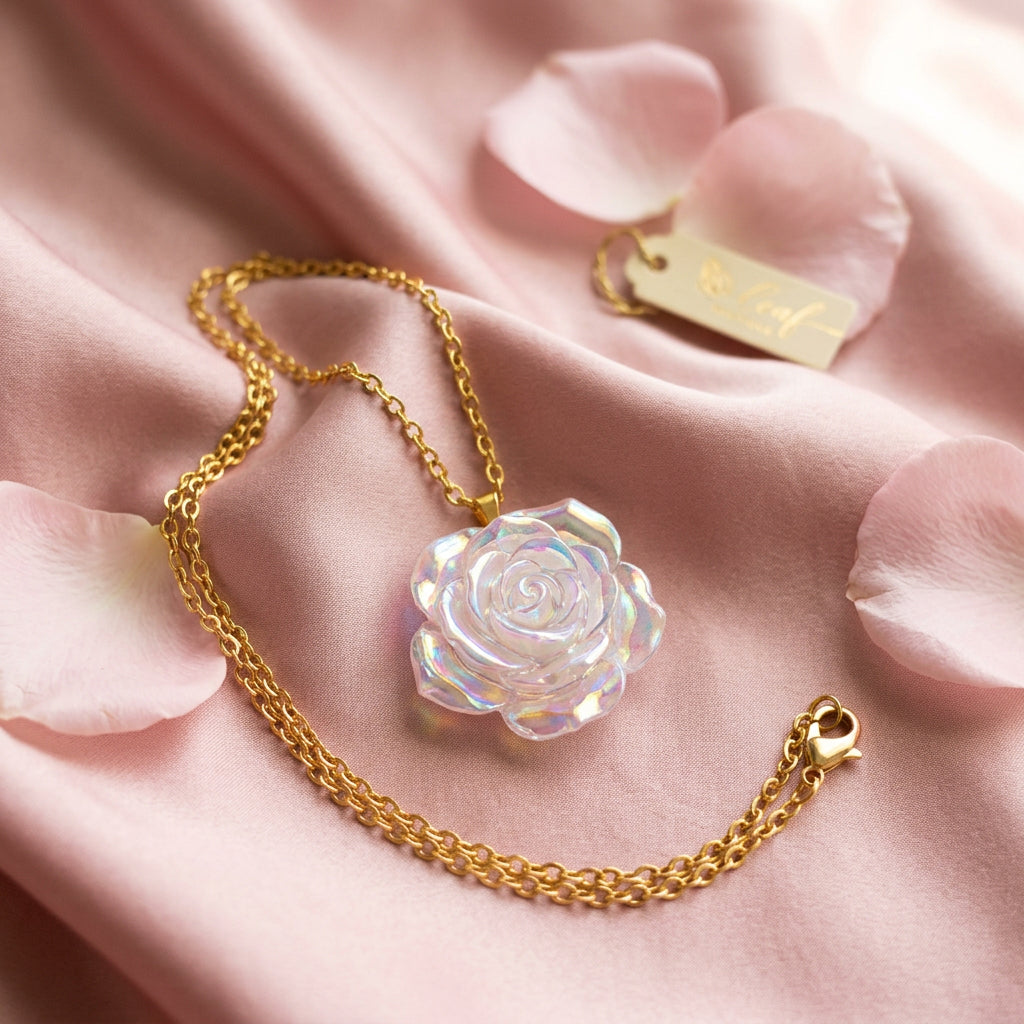 A gold chain necklace with a translucent, iridescent white rose-shaped pendant displayed on a black velvet jewelry bust.
