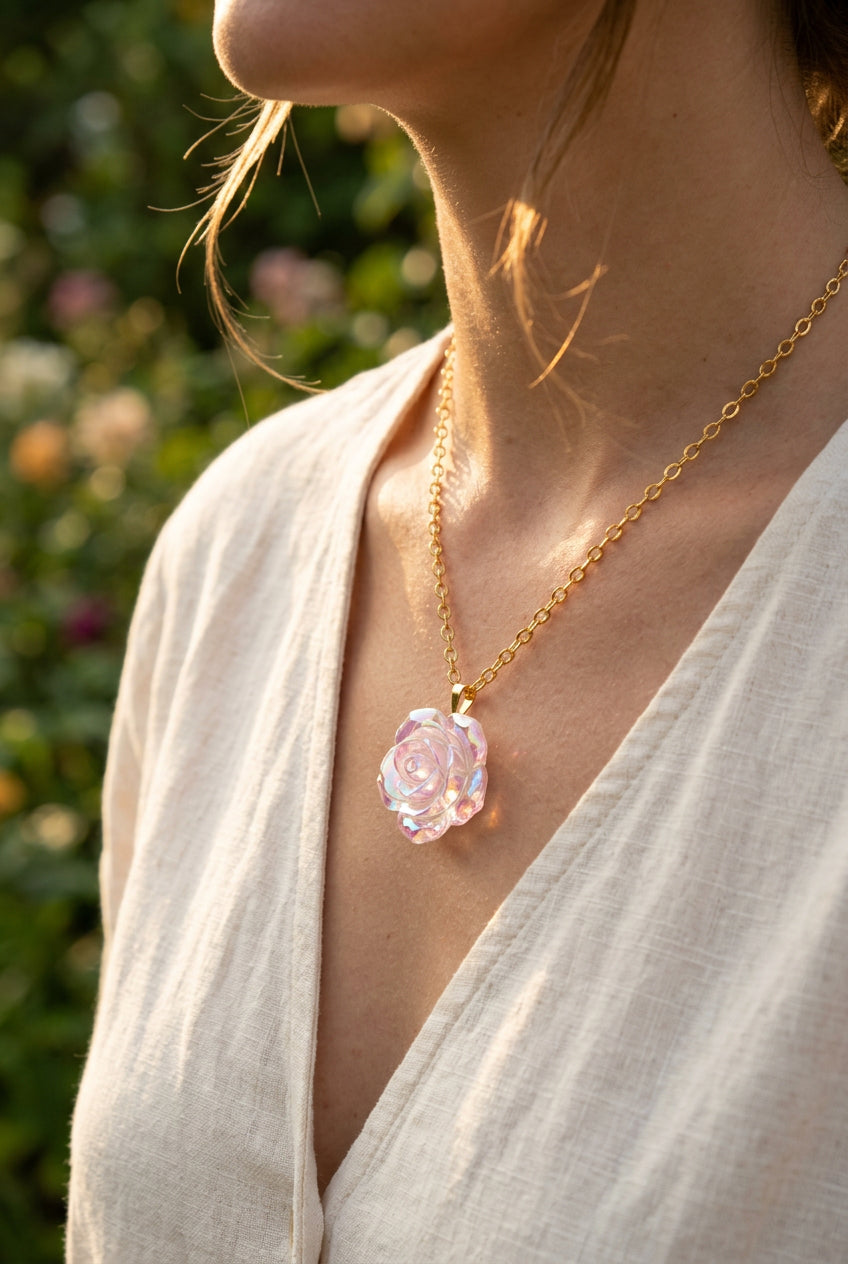 A gold chain necklace with a faceted, flower-shaped pendant made of an iridescent, pearly material, displayed on a black velvet jewelry bust.