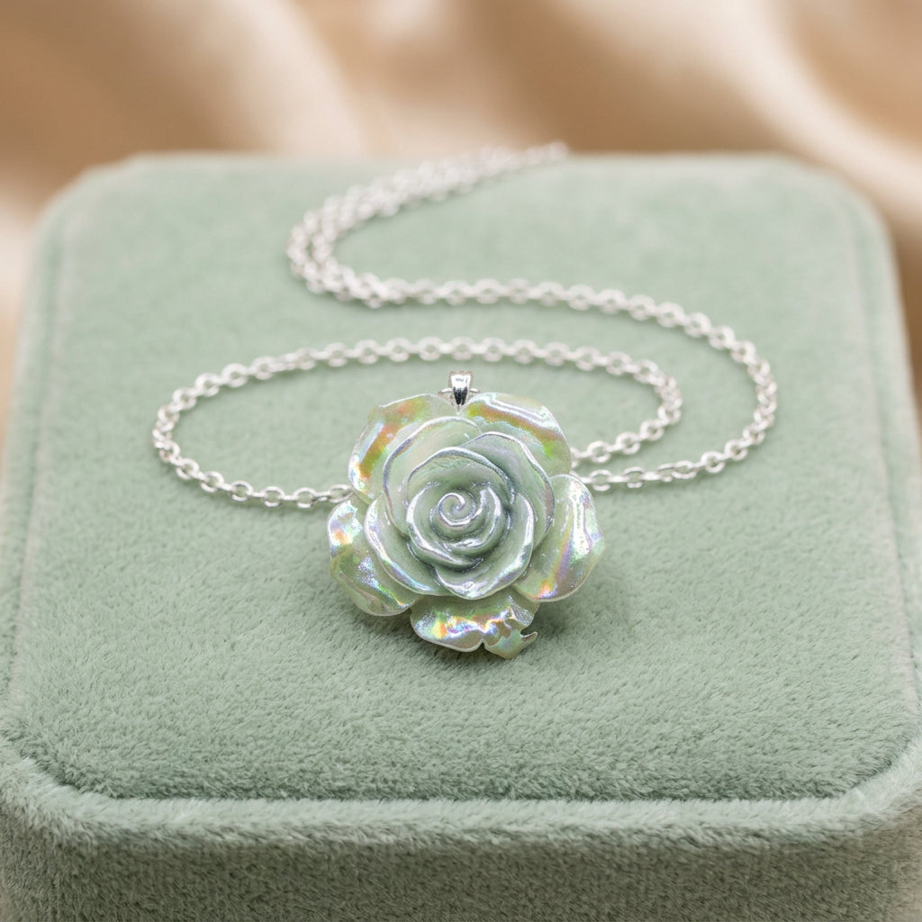 A silver chain necklace with a rose-shaped pendant made from iridescent mother-of-pearl, displayed on a black velvet jewelry bust against a white background.