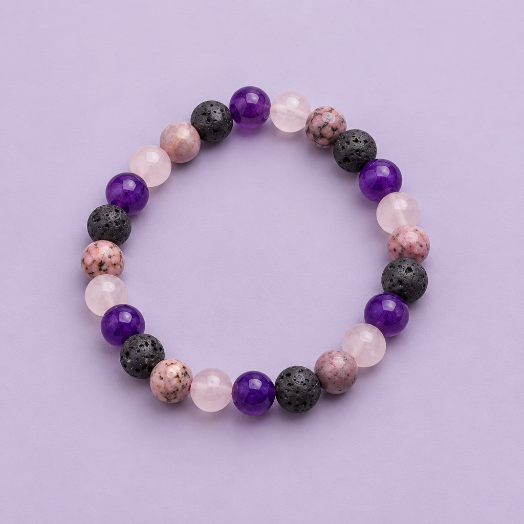 A beaded stretch bracelet made of round gemstone beads in purple, pink, and dark gray, arranged in a circle on a plain light gray background.