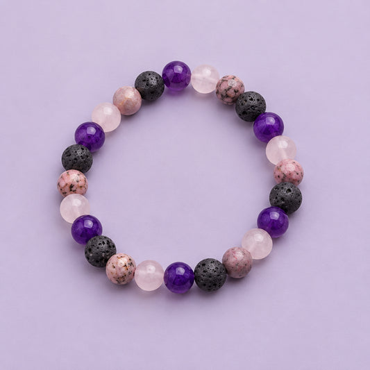 A beaded stretch bracelet made of round gemstone beads in purple, pink, and dark gray, arranged in a circle on a plain light gray background.