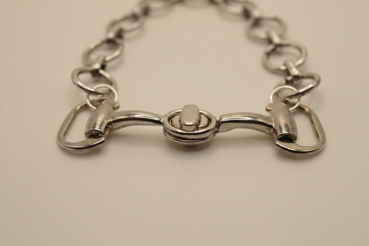 A silver horsebit chain bracelet with a central bit clasp, displayed on a plain light gray background.