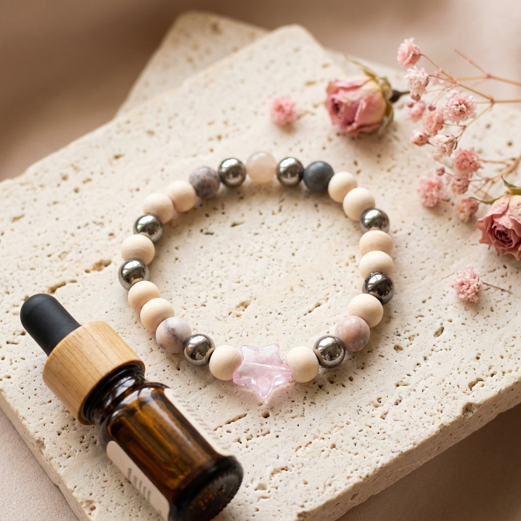 A beaded stretch bracelet featuring light beige wooden beads, polished silver metal beads, marbled stone beads, and a central pink translucent star charm, displayed on a plain light gray background.