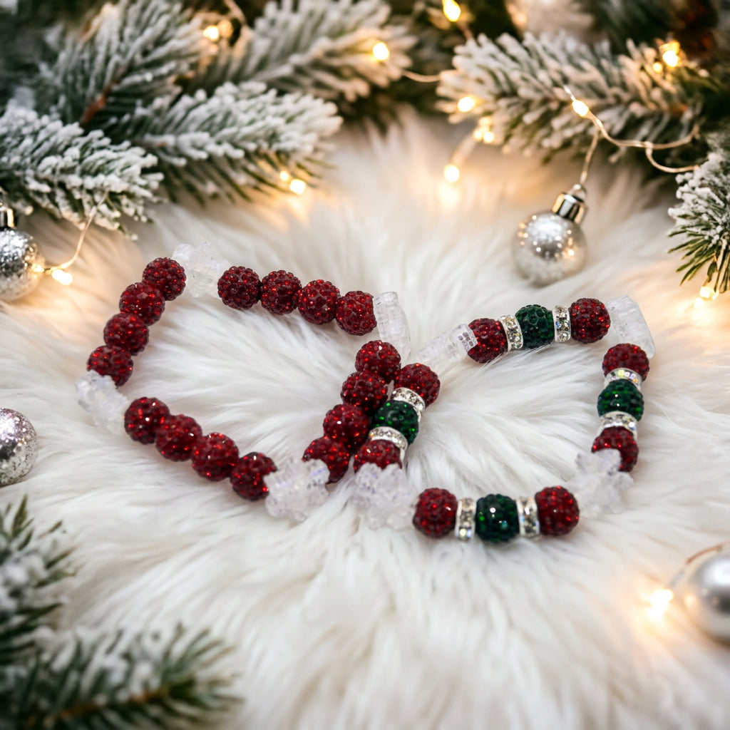 Two beaded stretch bracelets on a plain light gray background. One bracelet features dark red glittery beads with white crystal-like accents, and the other features dark red glittery beads with dark green and silver spacer beads.