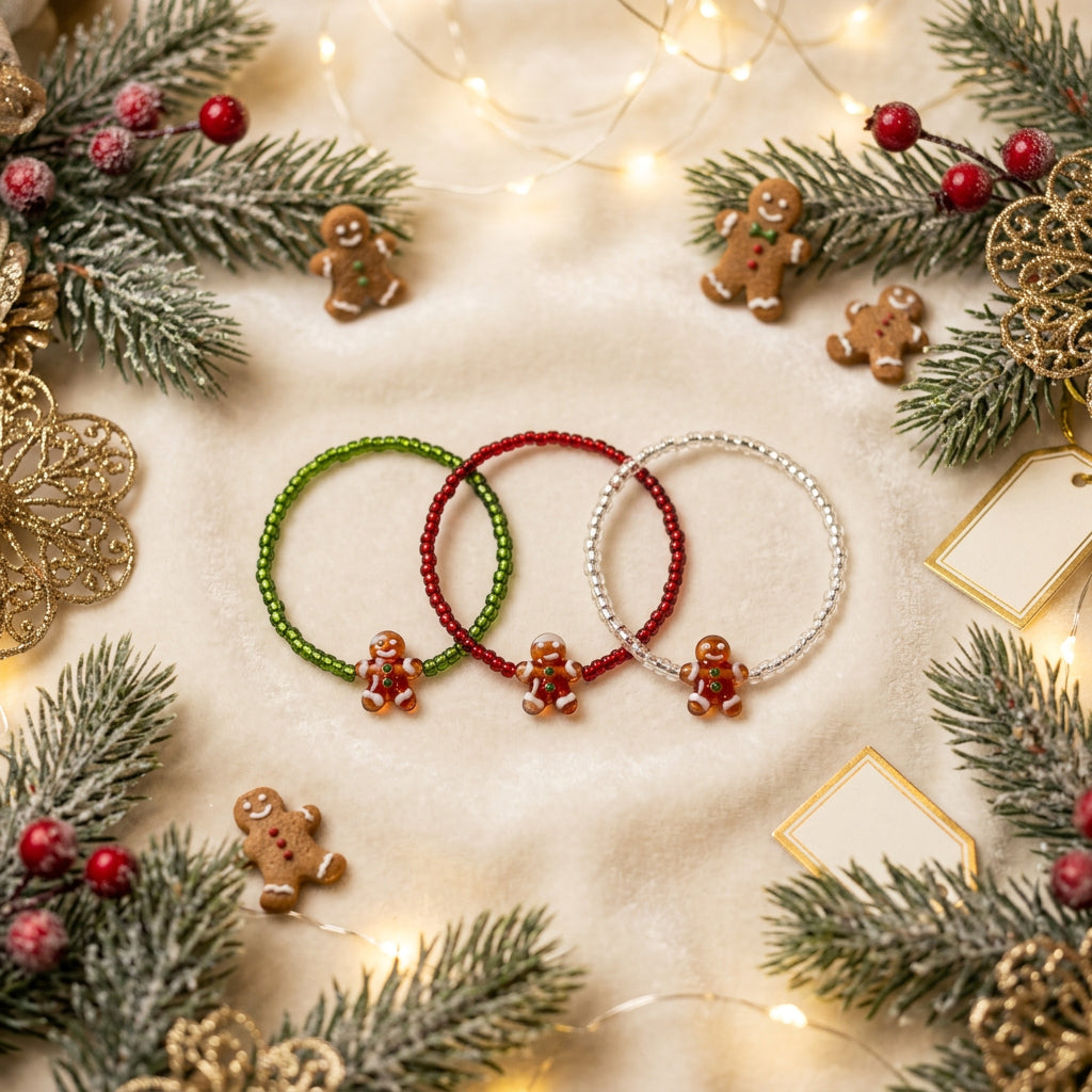 Three beaded stretch bracelets in green, red, and silver, each featuring a small orange butterfly charm, displayed on a plain white background.