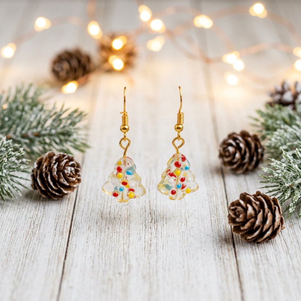 A pair of gold-tone dangle earrings with colorful enamel details, displayed on a clear acrylic stand against a neutral gray background.