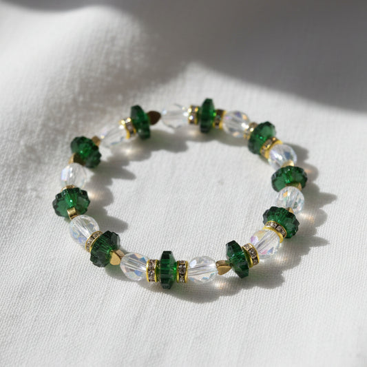Necklace with green and gold beads on a gray background