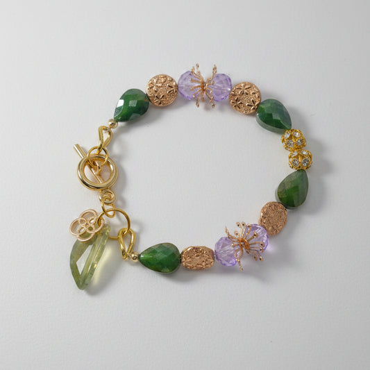 Bracelet with gold clasp and colorful beads on a gray background