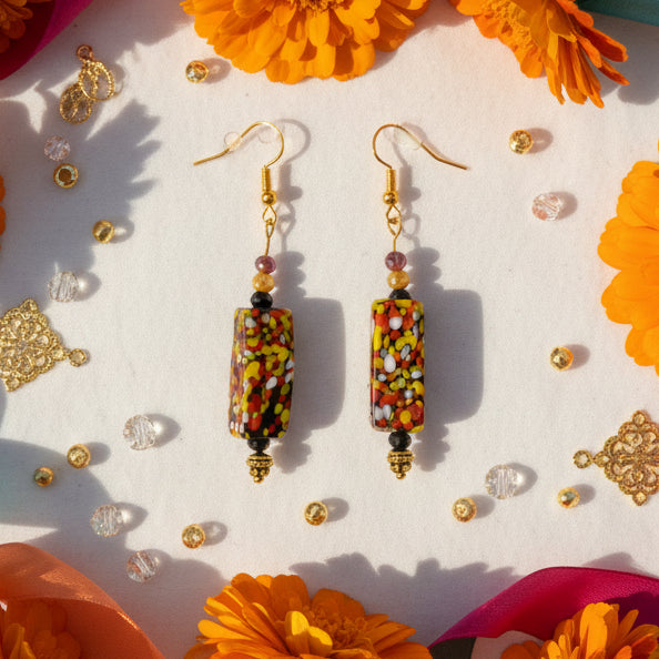 Colorful beaded earrings on a gray background