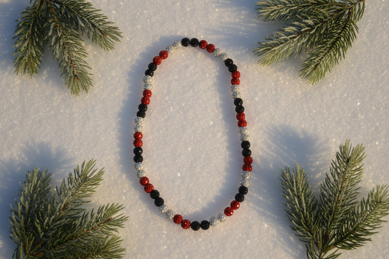 A beaded necklace with alternating red, black, and silver-white textured beads, displayed on a white background.