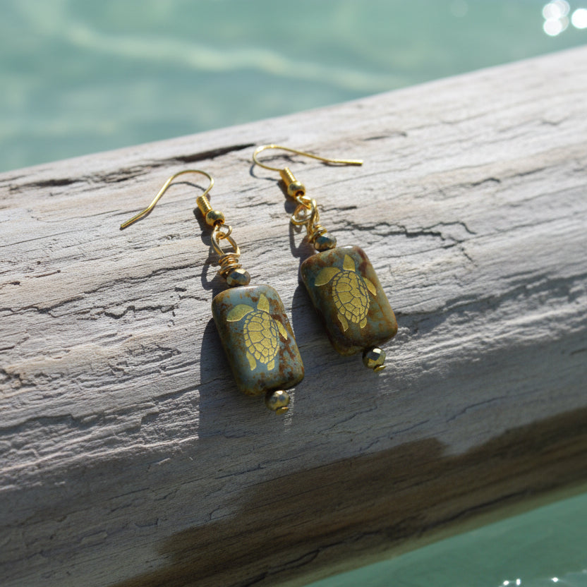 Pair of earrings with turtle design on a gray background