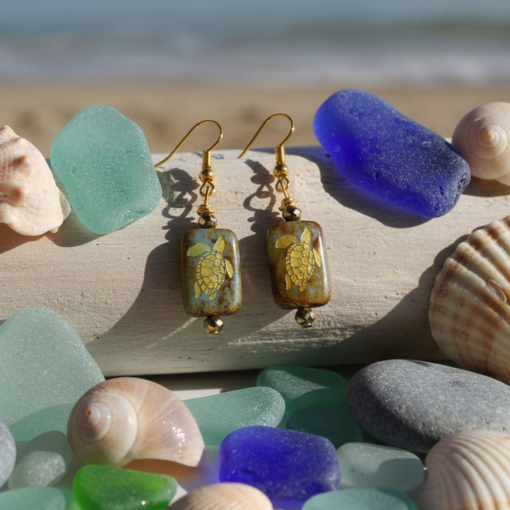 Pair of earrings with brown rectangular beads and gold accents on a gray background