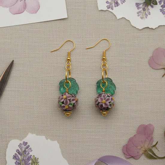 Pair of earrings with floral design on a gray background