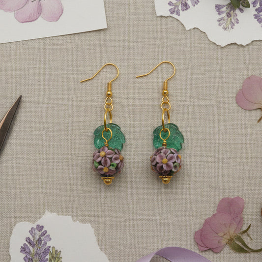 Pair of earrings with floral design on a gray background