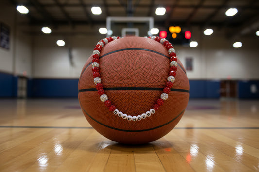 A beaded stretch bracelet featuring alternating red faceted beads and silver glittery beads, with silver letter beads spelling 'DEFENDERS' in the center, displayed on a white background.