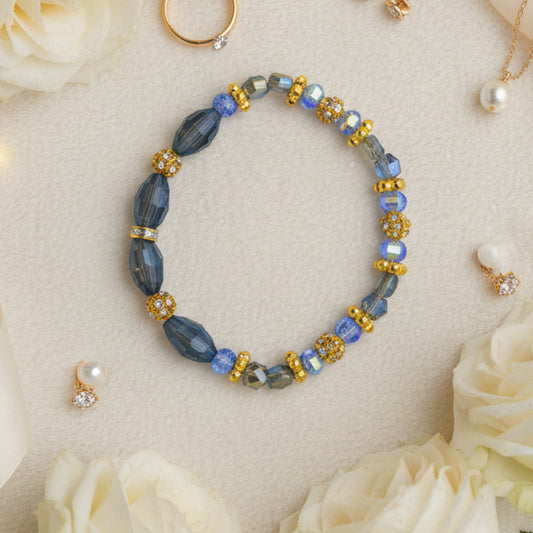 Beaded bracelet with blue, gold, and silver beads on a gray background