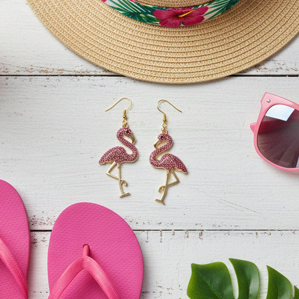 Flamingo-shaped earrings with pink and gold colors on a gray background