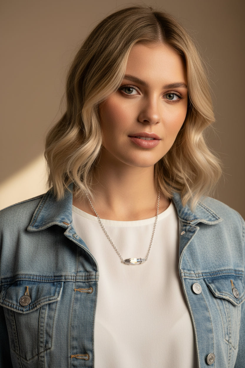 A silver chain necklace with a polished oval pendant displayed on a black velvet jewelry bust against a white background.